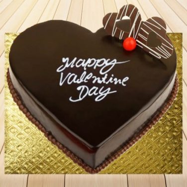 A heart-shaped chocolate cake for valentine day with "Happy Valentine's Day" written on top