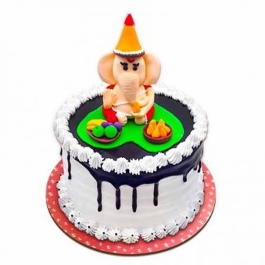 a dripping cake with ganpati on top