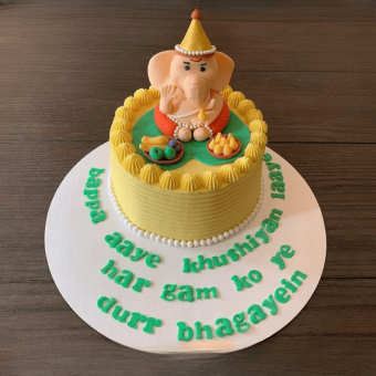 cream cake with ganpati on top