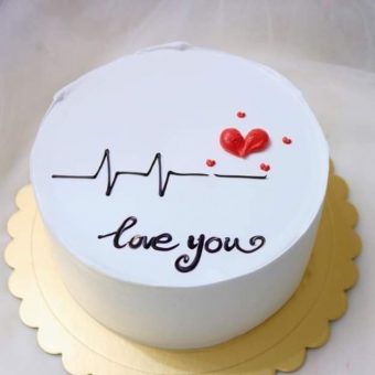 A white cake with a heartbeat line, red heart