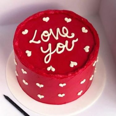 Red cake with "Love You" in white, surrounded by small heart decorations
