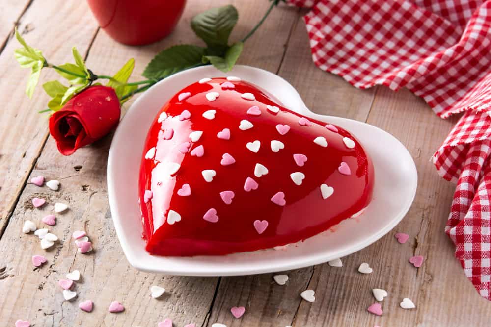 red velvet heart shaped cake for valentine day with a red rose