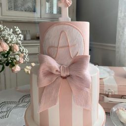 Pink cake with initial 'A' and ballet topper"