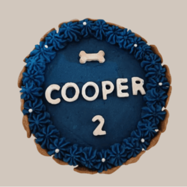 Blue dog birthday cake with bone decoration and name "Cooper"