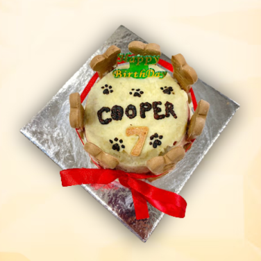 Bone Crown Cake for dogs topped with name, number, and biscuit bones, wrapped in red ribbon.
