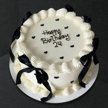 white cake with black ribbon