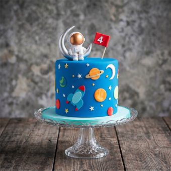 Blue astronaut cake with 3D silver moon topper and red number 4 flag