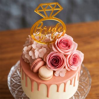 bride to be drip cake with floral topper front view