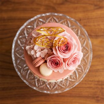 bride to be drip cake with floral topper top view