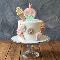 Pastel cake with 2nd birthday topper, fondant cupcakes, and ice cream cones